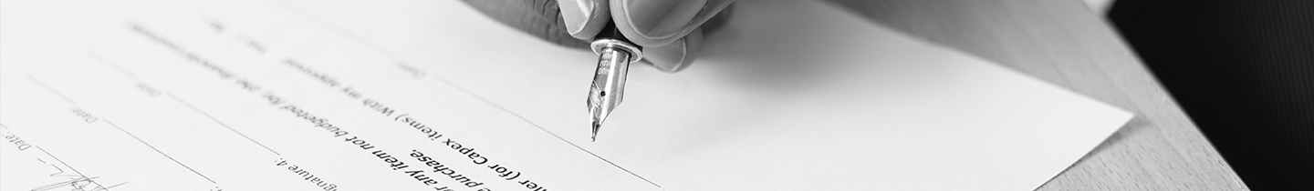 Fotografia de uma mão assinando um contrato com uma caneta