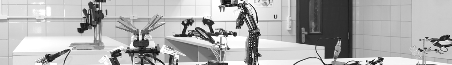 Fotografia do laboratório de robótica com robôs em exposição na mesa